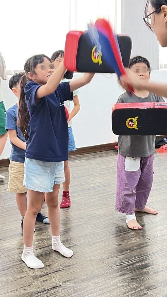 孩子握住防護墊,現場進行格擋練習